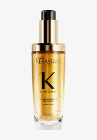 Kérastase Elixir Ultime, doorzichtige glazen fles met gouden accenten, pompdop, gevuld met gouden olie, voorzien van zwarte tekst, inhoud 75 ml.
