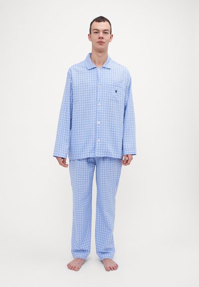 Set de pijama în carouri albastre, cu mâneci lungi, închidere cu nasturi și un buzunar pe cămașă. Pantalonii au carouri asortate. Textură de țesătură moale.
