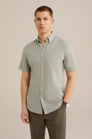 Kortærmet, lysegrå skjorte med knapper, lavet af et glat stof, med krave, brandlogo og slim fit, båret med brune bukser.