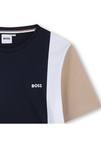 Camiseta de algodón en bloques de color azul marino, blanco y beige, con cuello redondo y un pequeño logotipo blanco "BOSS" en el pecho.