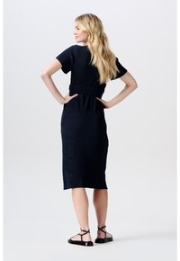 Marineblaues Midikleid mit kurzen Ärmeln und tailliertem Schnitt. Es hat eine gerippte Textur und ein glattes Finish. Kombiniert mit schwarzen flachen Sandalen.
