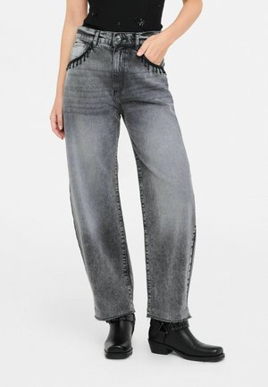 Grijze denim wijde broek met decoratieve kraalaccenten op de zakken, afgewerkte zoom en gecombineerd met zwarte enkellaarsjes met gespen.
