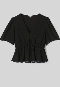 Blouse noire à manches courtes avec col en V, boutons sur le devant, ceinture nouée à la taille, tissu texturé et bas évasé style peplum sur fond gris clair.