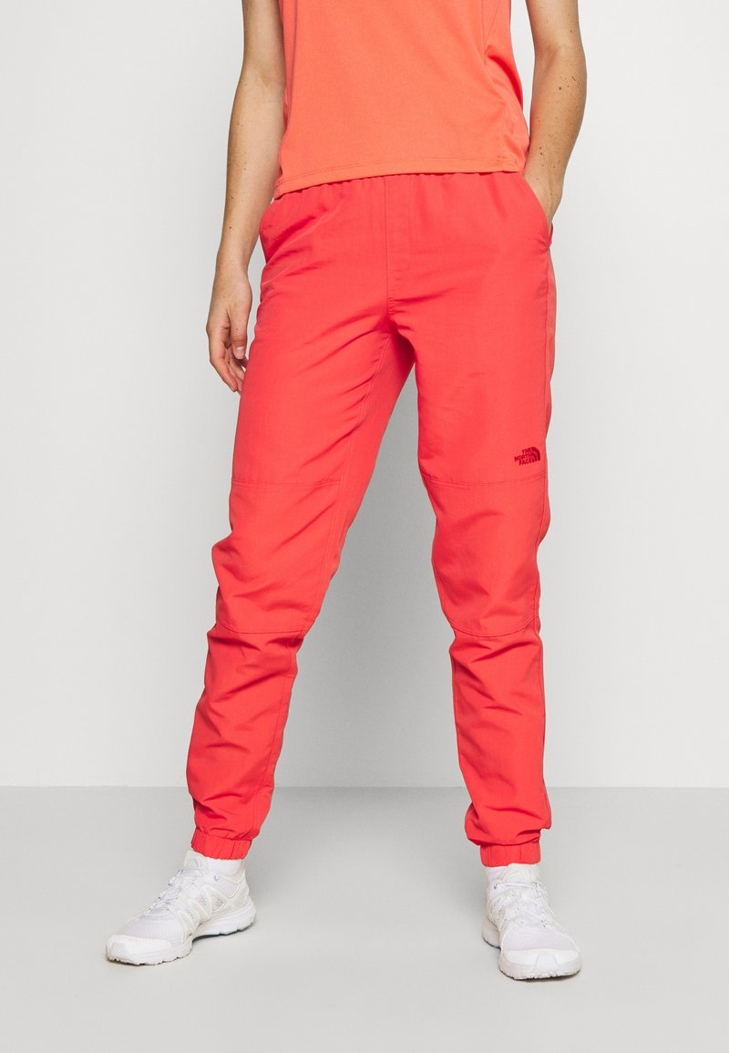 Punaiset kevyet juoksuhousut, joissa on elastinen vyötärönauha ja lahkeen suut, tasku- ja pieni musta logo vasemmassa reisessä.