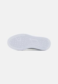 Witte sneakersole met een gestructureerd grip patroon en een opvallend logo. Glad rubbermateriaal met een ronde neus en een platte hakontwerp.