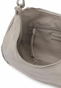 Interno di una borsa in finta suède grigia chiaro con chiusura a zip, una tasca laterale e dettagli in metallo argentato lungo il bordo. Struttura liscia.