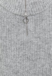 Pull en rib à col haut de couleur grise avec une fermeture éclair à quart de longueur. Texture douce et fermoir en métal argenté. Design simple et fonctionnel.