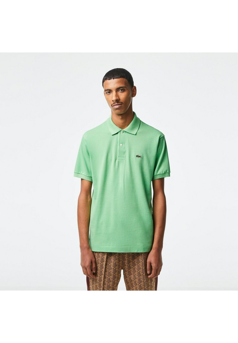 Polo shirt in een levendige groene kleur, met korte mouwen, een geribbeld kraagje en een subtiele logo op de borst. Zachte stof met een gladde textuur.