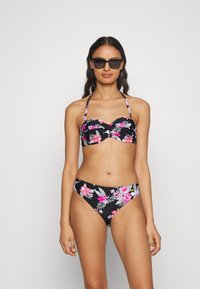 Juodas bikini maudymosi kostiumėlis su rožinėmis ir baltomis gėlėmis. Viršus turi širdelės formos iškirptę ir reguliuojamus petnešėles; apačia turi klasikinį kirpimą.