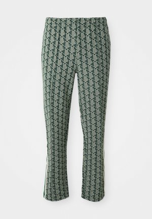 Green slim-fit pants with white geometric pattern and side stripe detail, displayed against a white background.