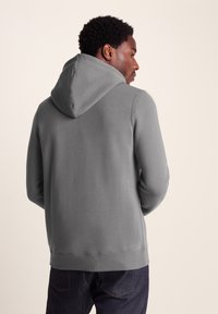 Grey, hooded sweatshirt with a smooth texture, long sleeves, and a kangaroo pocket. Features a ribbed hem and cuffs, shown from the back.
