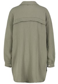 Olijfgroene shirt, lange mouwen met knoopmanset, textiel met een subtiel gekreukt patroon, rugpassement detail en rechte snit.