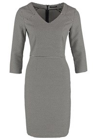 Robe à motifs en zigzag noir et blanc avec un col en V, des manches trois-quarts et une silhouette ajustée, fabriquée dans un tissu lisse.