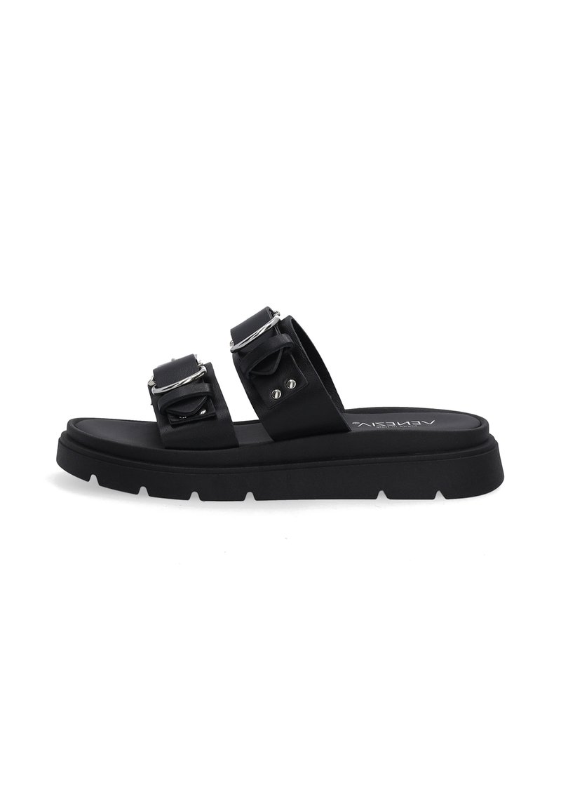 Zwarte platte sandalen hebben twee brede banden met gespen en een stevige rubberen zool, gepositioneerd op een effen witte achtergrond.