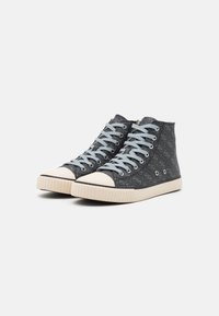 Zapatillas altas de lona gris oscuro con un patrón de logo, cordones azul claro y una suela de goma beige con un capuchón de toe texturizado.