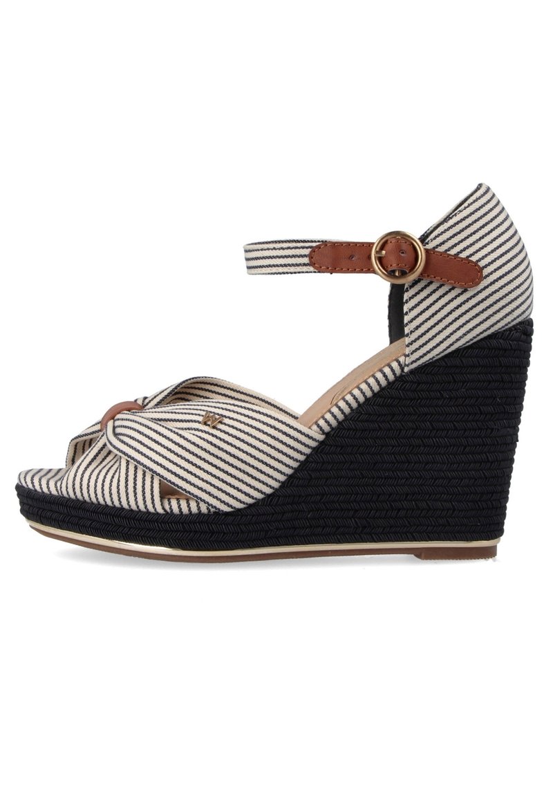 Sandalo con zeppa a strisce in una combinazione di colori beige e navy, superiore in tessuto, cinturino alla caviglia regolabile e piattaforma intessuta nera testurizzata.