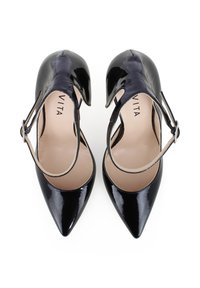 Talons en cuir verni noir avec un bout pointu, une bride au niveau de la cheville et un design découpé. L'intérieur présente un revêtement beige clair et un logo de marque.