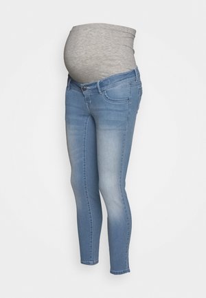 Jean de maternité bleu clair avec panneau en tissu gris extensible au niveau du ventre pour le confort et le soutien.