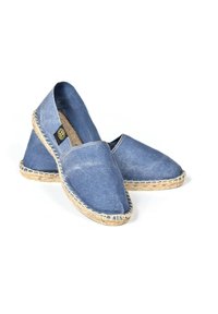 Espadrilles en denim avec un bout arrondi et une semelle en jute, dotées d'un bord tissé et d'un dessus en tissu bleu. Surface texturée avec un minimum de coutures.