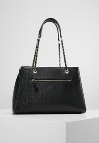 Sac à main noir en matériau synthétique texturé. Il présente une grande poche zippée, des poignées avec accent en chaîne et un design angulaire.