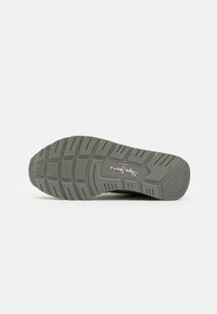 Sole grigia di sneaker con un design del battistrada a motivo. Presenta una gomma testurizzata per una presa migliore e include il marchio nella zona dell'arco.