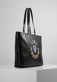 Zwarte leren shopper met twee hengsels, voorzien van een kleurrijk "LOVE MOSCHINO" grafisch ontwerp aan de voorkant. Soepele textuur, rechthoekige vorm.