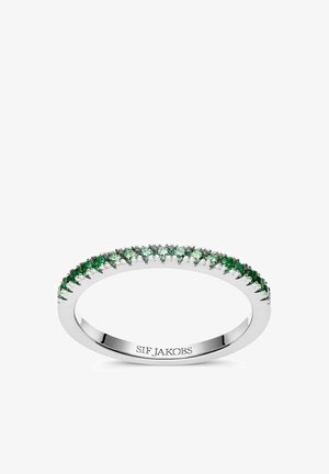 Grön ädelstensring med en slät silverring, som har flera gröna stenar som är inställda i en klolösning runt omkretsen.