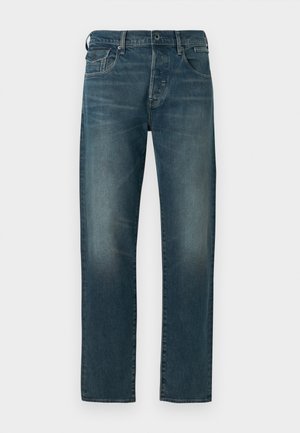 Jean en denim bleu avec une coupe droite, doté d'une taille mi-haute, d'une finition à cinq poches et d'un délavage usé avec un minimum d'usure.