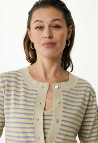 Stickad cardigan med växlande lila och gula ränder, en ljusbeige halsringning och runda knappar framtill.