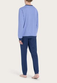 Maglia da pigiama a maniche lunghe blu con motivo, dettagli blu navy, abbinata a pantaloni da pigiama blu navy, texture morbida e vestibilità rilassata.