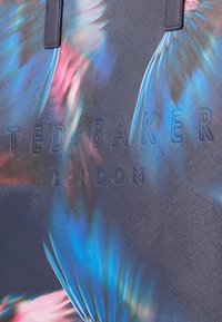 Borsa a tracolla con motivo floreale blu e rosa realizzata in tessuto testurizzato, con logo impresso "Ted Baker London" e manici robusti.