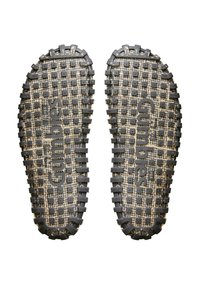 Black rubber soles with a textured grip pattern, featuring raised squares and the word "Gumbies" embossed in the center.
