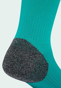 Türkise Socke mit einem Rippendesign und einer schwarzen verstärkten Ferse. Sie hat eine glatte Textur mit einem Farbblock in kontrastierender Farbe im Fersenbereich.