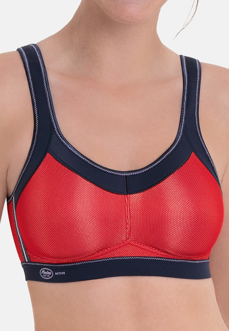 Soutien-gorge de sport rouge et marine avec une texture en maille, des bretelles larges et des accents cousus, présentant un design triangulaire et une bande élastique.