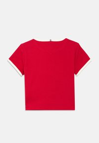 Red short-sleeve t-shirt with a ribbed texture, featuring a white neckline and sleeve cuffs. V-shaped back detail at the neckline.