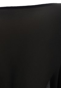 Tessuto nero liscio con una leggera lucentezza piegato lungo il bordo superiore su uno sfondo bianco.