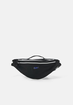 Zwarte heuptas met witte ritssluitingzoom, bovenhandgreep, verstelbare band en klein blauw Nike-logo op de voorkant in het midden.