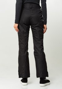 Pantalones de esquí negros con una textura lisa, diseño de pierna estrecha, cintura ajustable y ventilaciones con cremallera en los tobillos.