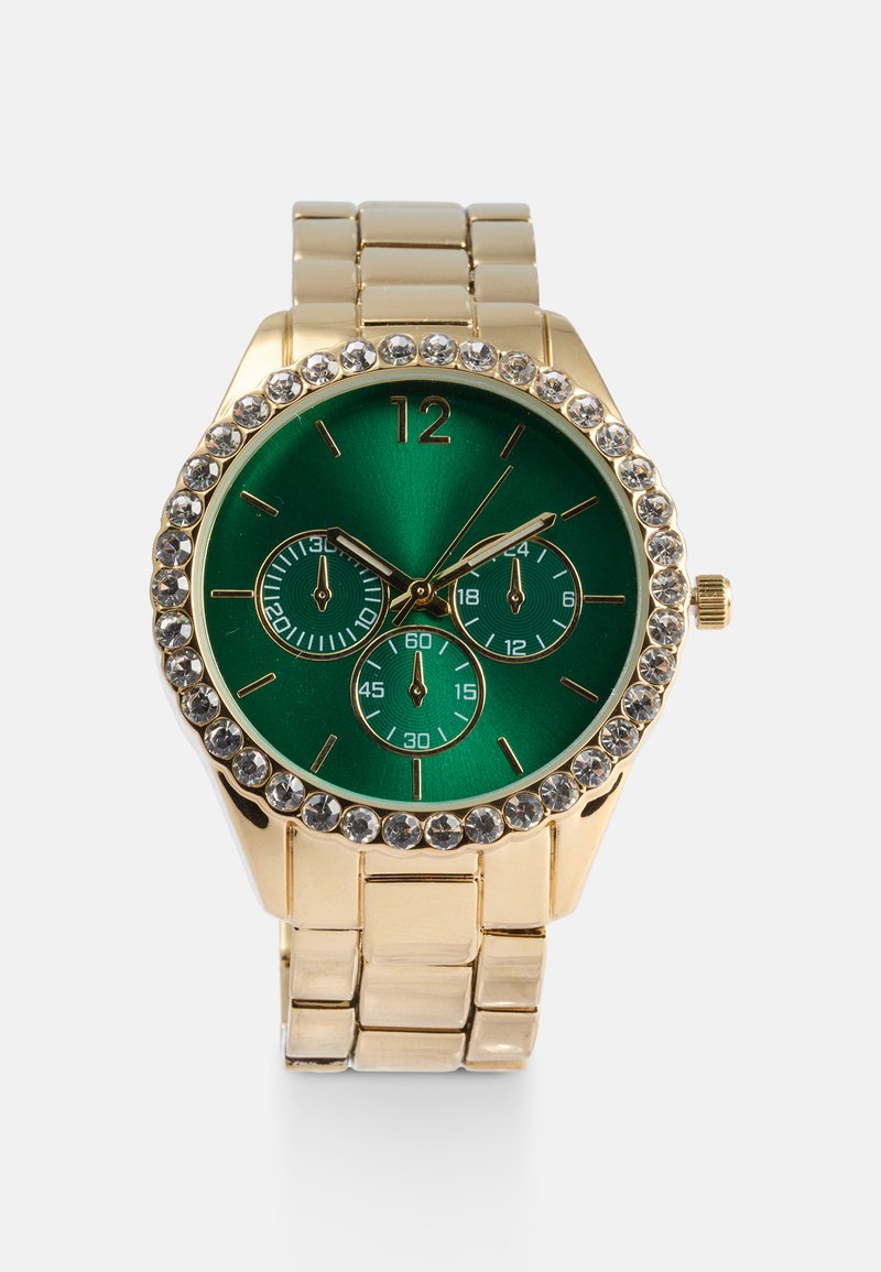 Montre-bracelet dorée avec un cadran vert, trois sous-cadrans et une lunette ornée de strass. Bracelet en métal avec une texture brossée.