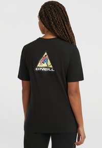 Camiseta negra con un gráfico de triángulo en la espalda que presenta un diseño colorido y el texto "ONEILL". Mangas cortas y un corte relajado.