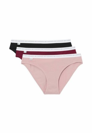 Tre slip da donna in rosa, bordeaux e nero con elastici bianchi in vita con il marchio Lacoste ripetuto e un piccolo logo verde a forma di coccodrillo.