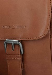 Borsa in pelle marrone con una superficie liscia, dotata di una fibbia metallica e del logo impresso "GREEN BURRY" sul risvolto.