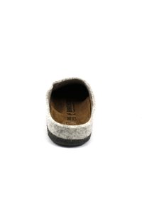 Grijze gevoerde slipper met een donkere rubberen zool. Het interieur toont een bruine inlegzool met maatmarkeringen. Rond toelopende neus en open achterkant ontwerp.