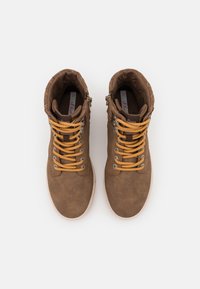 Chaussures montantes en daim marron avec une surface texturée, dotées de lacets orange, d'œillets argentés et d'une fermeture éclair latérale.