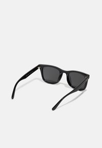 Ochelari de soare negri cu rame pătrate și lentile întunecate. Material din plastic lucios. Accentuati cu mici accesorii metalice pe tirișe.