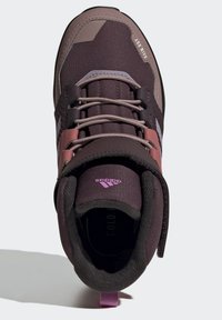 Fioletowe buty trekkingowe z teksturowanym wierzchem z tkaniny, gumową podeszwą i kontrastującymi różowymi akcentami. Posiadają wyściełany kołnierz i logo na języku.
