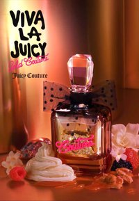 Flacon de parfum Juicy Couture Viva La Juicy Gold Couture avec bouchon en cristal, nœud noir à pois blancs, entouré de crème, baies et fleurs.