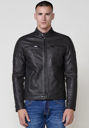 Chaqueta de cuero negra con collarín, cierre delantero, dos bolsillos en el pecho y detalles texturizados en los hombros.