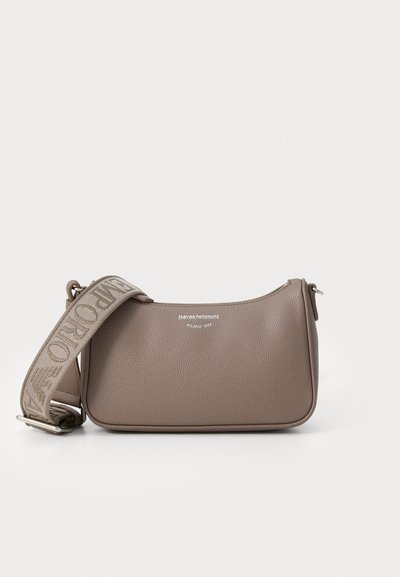 Brown textured leather handbag with a curved shape, featuring a logo detail and a detachable patterned strap. Accents include a zip closure.