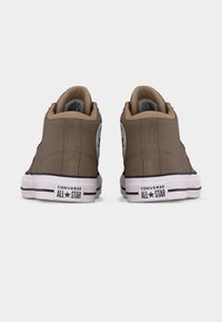 Par smeđih visokih tenisica Converse All Star prikazanih s leđa na bijeloj pozadini.